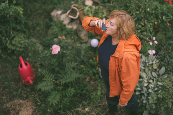 Woman in garden with inhaler